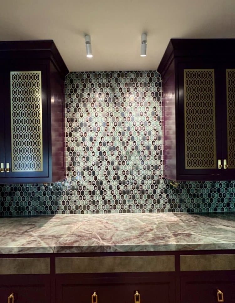 Hexagonal glass mosaic tile feature wall above a stone countertop